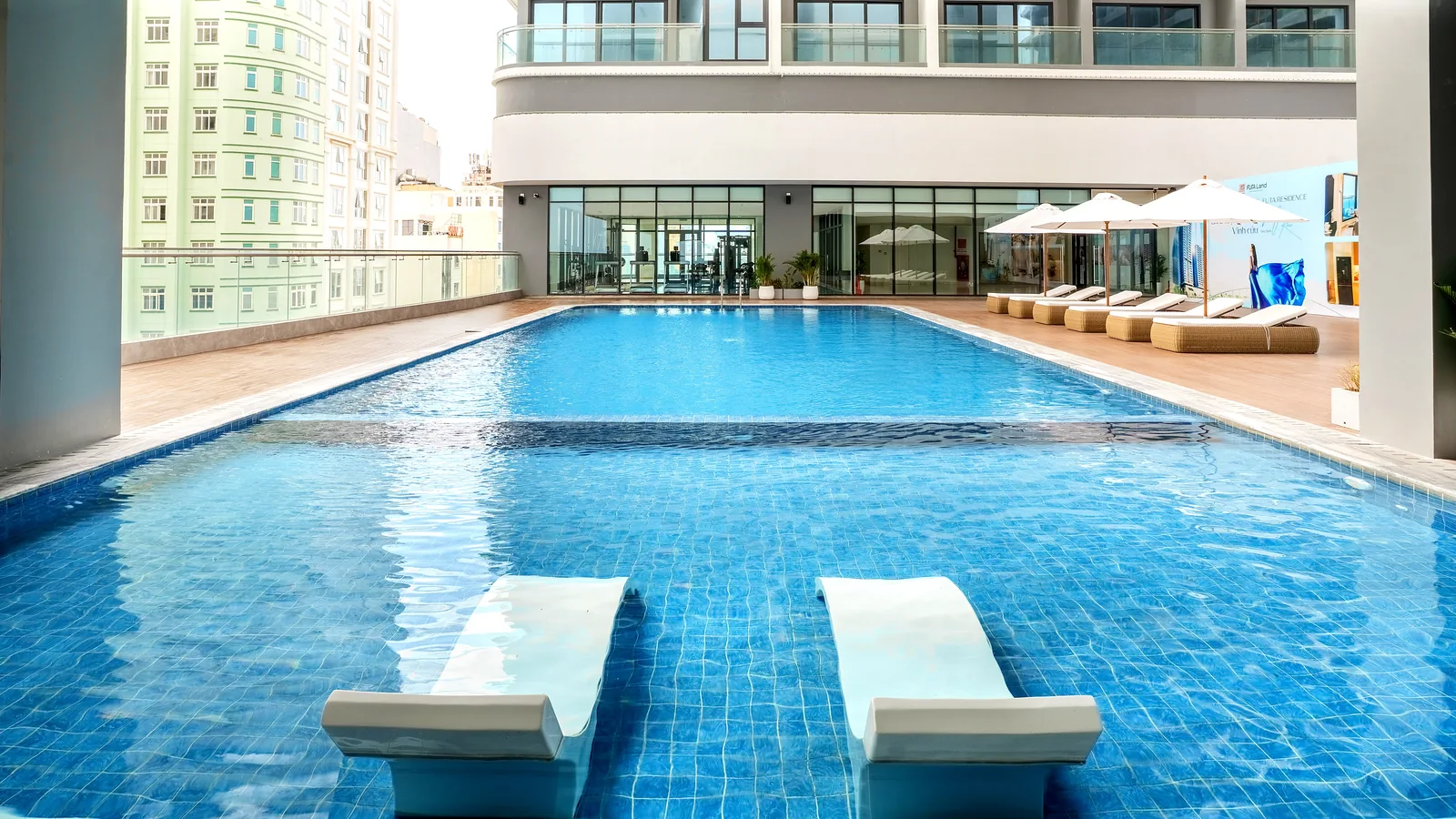 Swimming pool with tiled turquoise water and deck loungers at Maison D’Rose Đà Nẵng