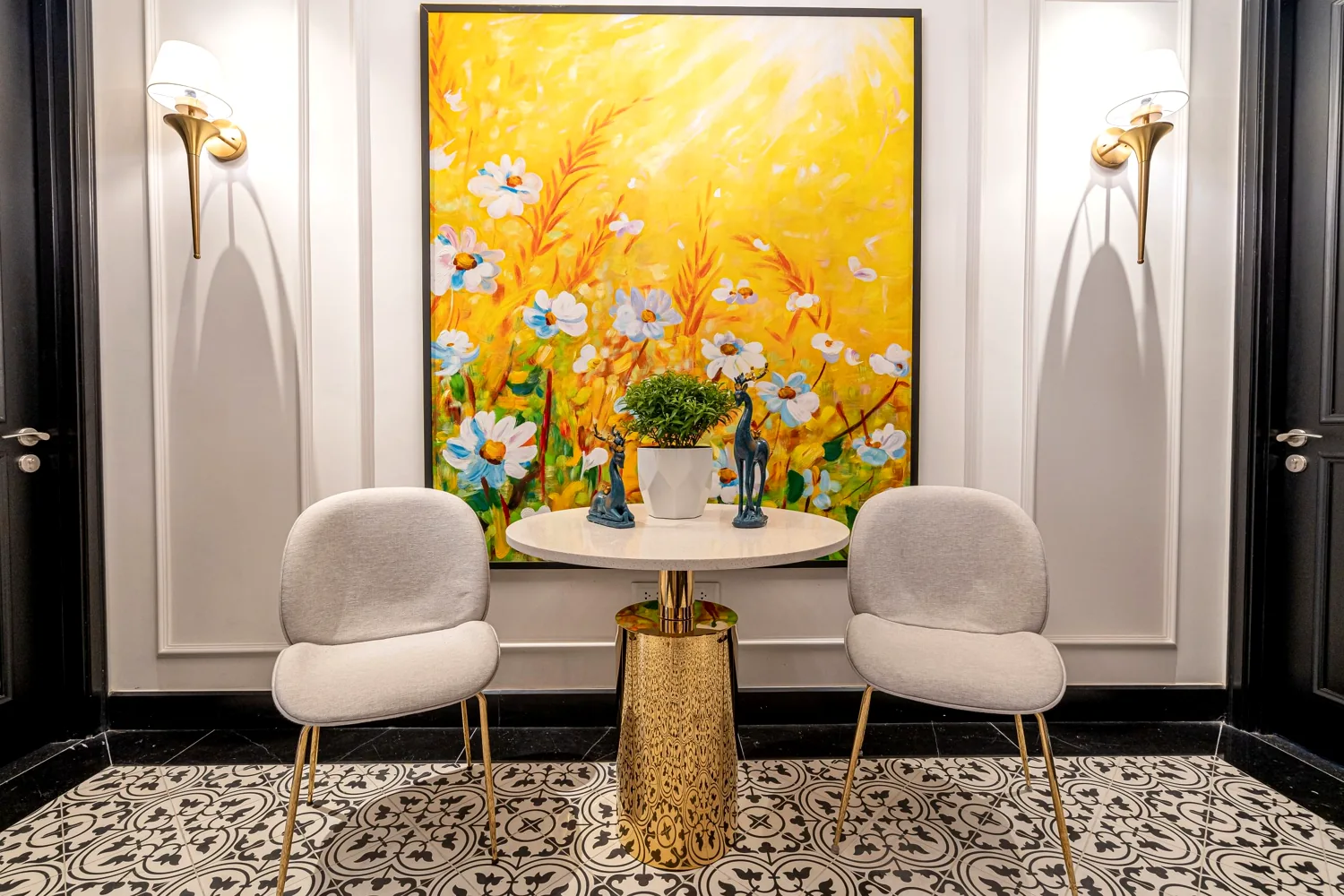 Indochine lounge nook with a sunny yellow floral painting, velvet chairs and encaustic tile floor at Maison D’Rose Phú Quốc